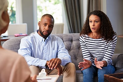 A person with a family member talking with a mental health professional.