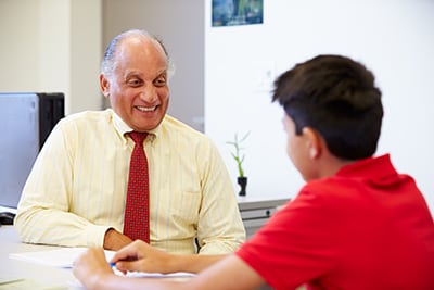 Latino teenage boy talking to a counselor