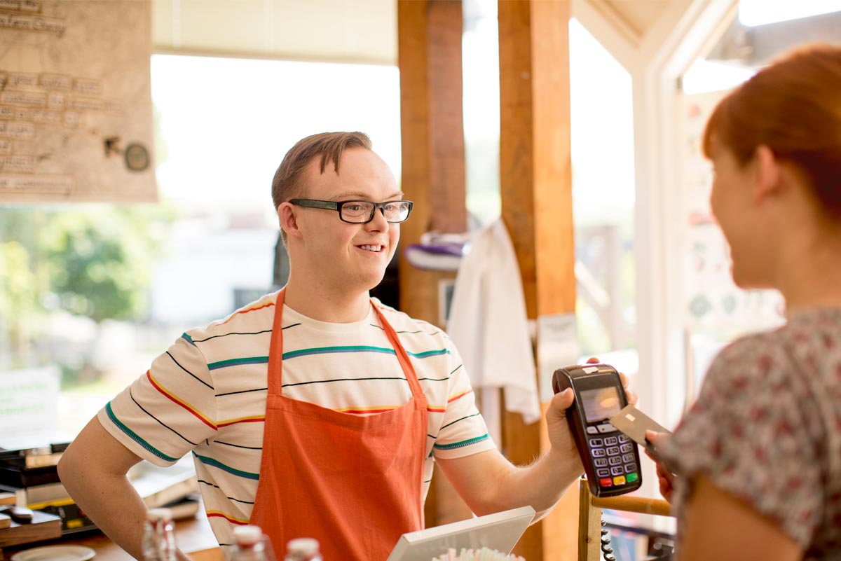 Photograph of a young man with Downs Syndrome working as a barista.