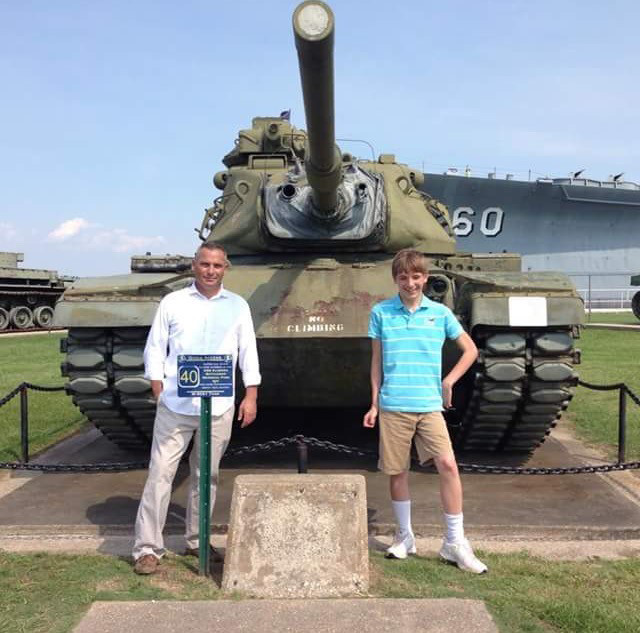 Image of Charles and Joshua Chester posing in front of a tank.
